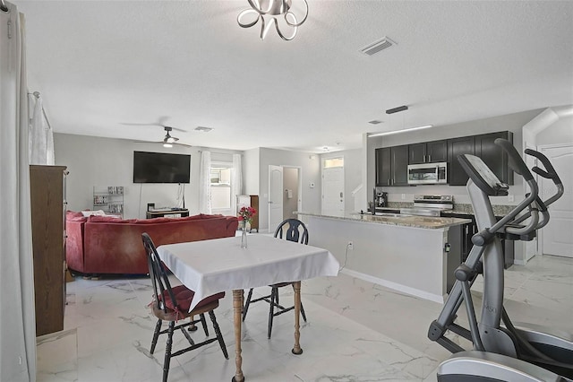 dining area with marble finish floor, visible vents, ceiling fan, and a textured ceiling