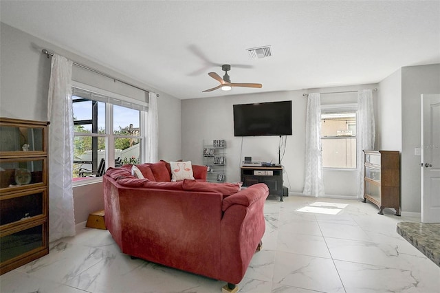 living room with marble finish floor, plenty of natural light, and visible vents