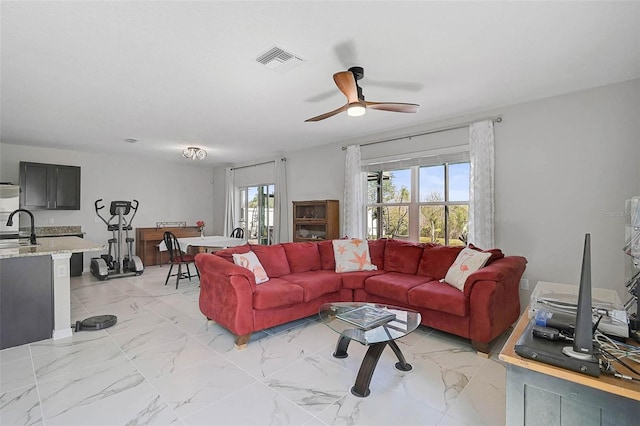 living area featuring marble finish floor, ceiling fan, and visible vents