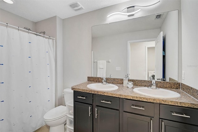 full bathroom featuring toilet, a sink, and visible vents