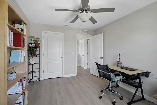 office with visible vents, ceiling fan, baseboards, and wood finished floors