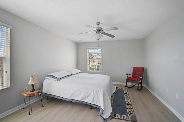 bedroom featuring light wood-type flooring, ceiling fan, and baseboards