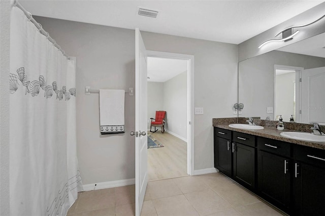 full bath with baseboards, a sink, visible vents, and tile patterned floors