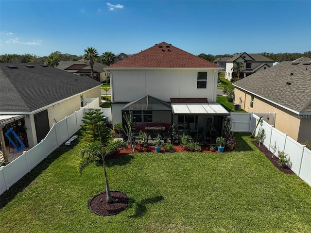 back of house featuring a yard, a fenced backyard, a residential view, and stucco siding