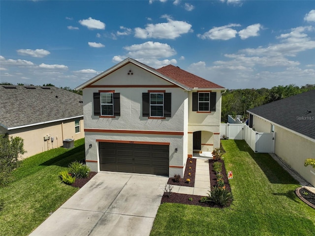 traditional-style home featuring stucco siding, concrete driveway, an attached garage, a gate, and a front lawn