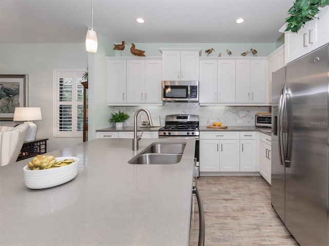 kitchen featuring stainless steel appliances, backsplash, and white cabinets