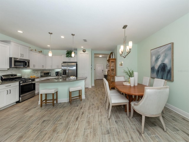 dining room with a toaster, visible vents, baseboards, and wood tiled floor