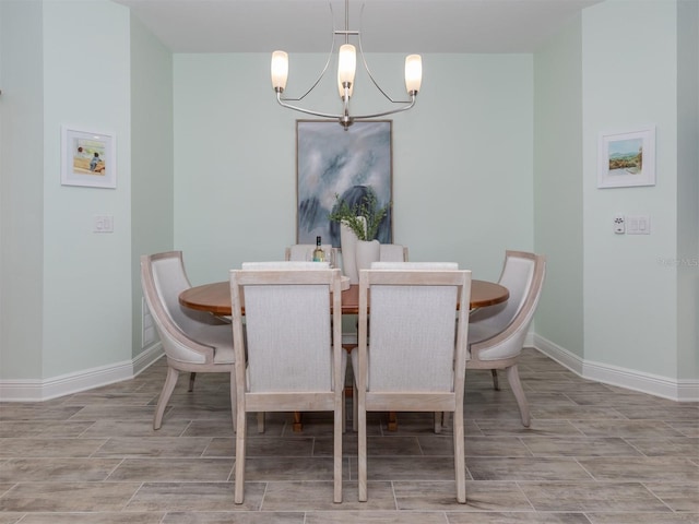 dining area featuring a chandelier, baseboards, and wood finish floors