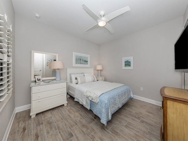 bedroom featuring wood finish floors, baseboards, and a ceiling fan