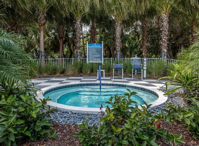 view of pool featuring a community hot tub and fence