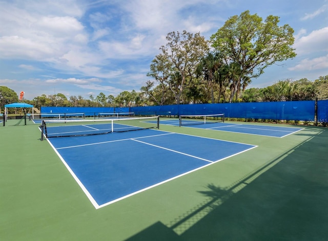 view of tennis court with community basketball court and fence