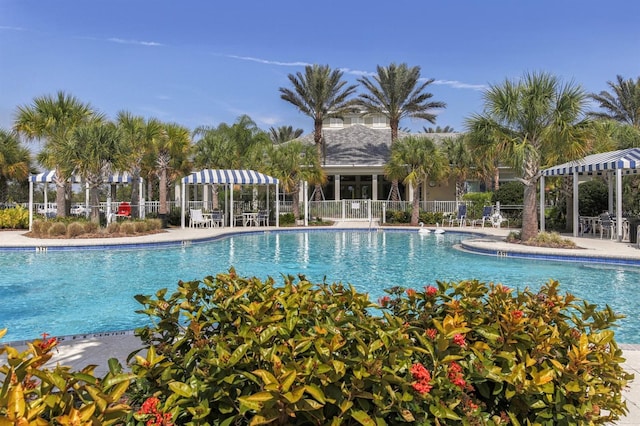 community pool with a patio and fence