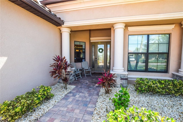 entrance to property featuring stucco siding and covered porch