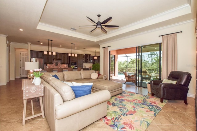 living room with light tile patterned floors, visible vents, a raised ceiling, and ceiling fan