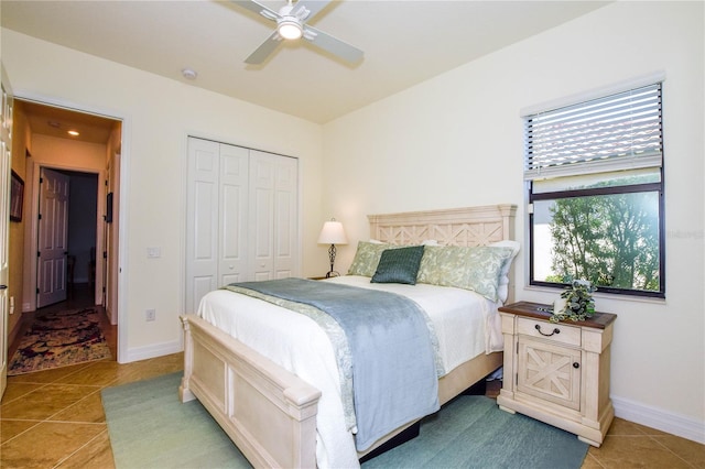 bedroom with tile patterned floors, baseboards, a closet, and ceiling fan