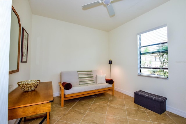 sitting room featuring tile patterned flooring, a ceiling fan, and baseboards