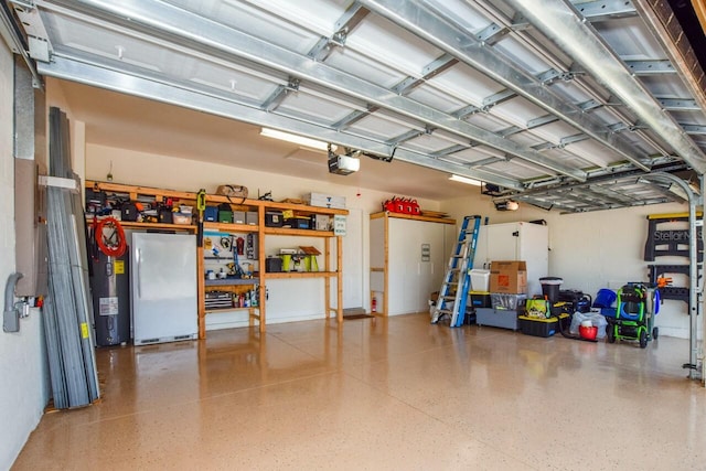 garage featuring water heater, a garage door opener, and freestanding refrigerator