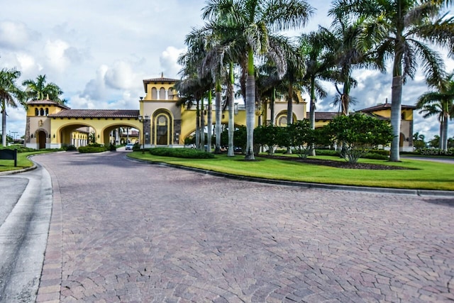 exterior space with a front yard, decorative driveway, and stucco siding