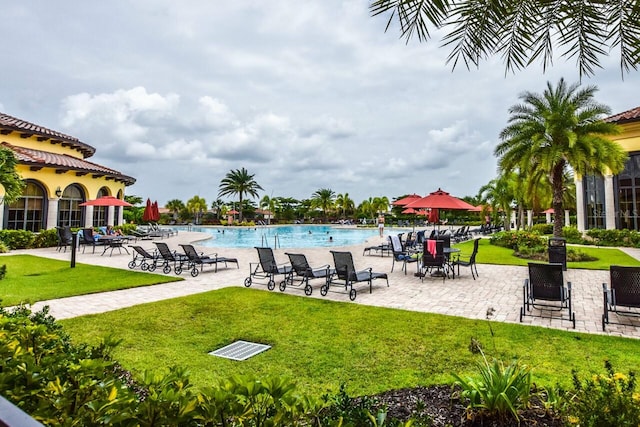 community pool featuring a patio area and a lawn