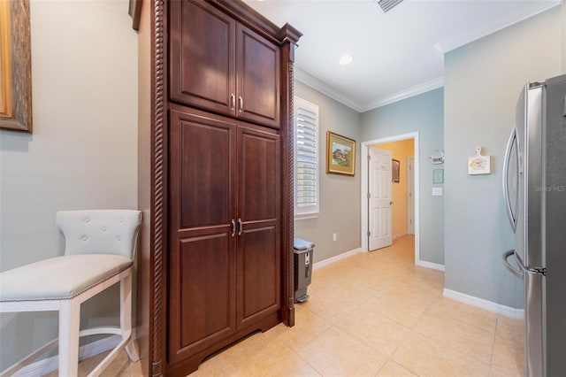 hall featuring light tile patterned floors, baseboards, visible vents, and ornamental molding