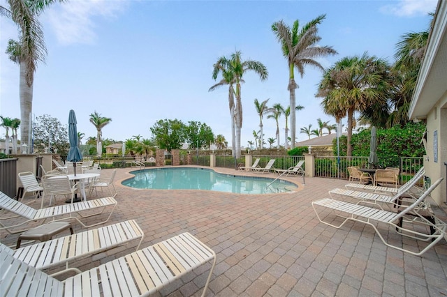 pool with a patio and fence