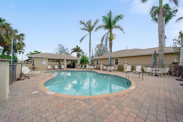 community pool featuring fence and a patio