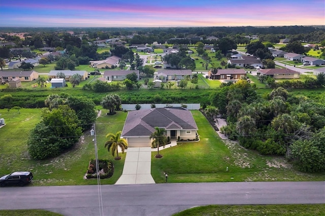 aerial view at dusk featuring a residential view