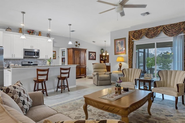 living room with light tile patterned floors, visible vents, vaulted ceiling, and a ceiling fan