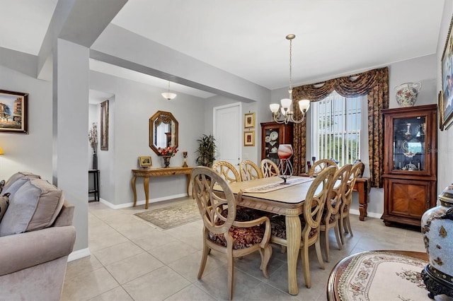 dining room with baseboards, a chandelier, and light tile patterned flooring