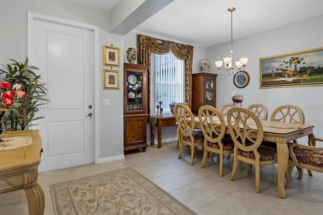 dining space with a notable chandelier, baseboards, and light tile patterned floors