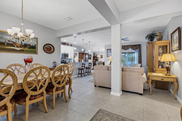 dining area with a chandelier, light tile patterned floors, visible vents, and baseboards