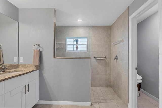 full bath featuring toilet, baseboards, a walk in shower, and vanity