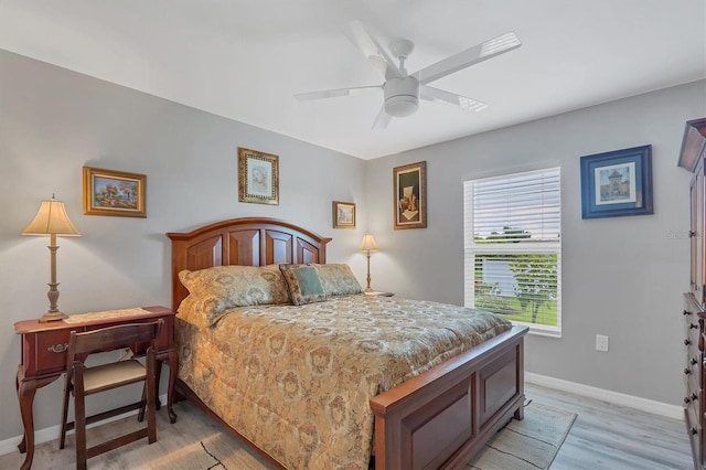 bedroom featuring light wood finished floors, a ceiling fan, and baseboards