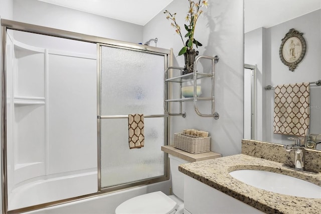 full bathroom featuring enclosed tub / shower combo, vanity, and toilet