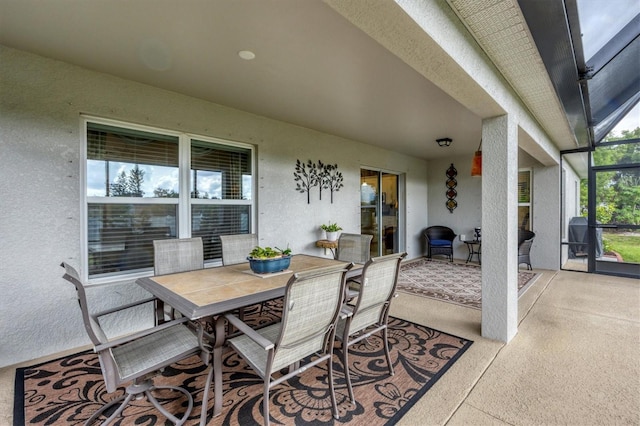 view of patio / terrace with outdoor dining space and a lanai