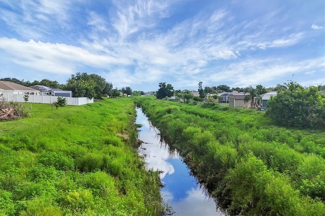 view of yard featuring a water view and fence