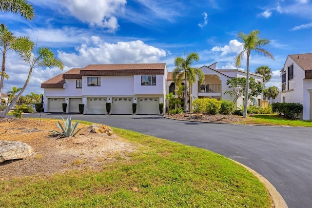 view of front of property featuring a garage, aphalt driveway, and stucco siding