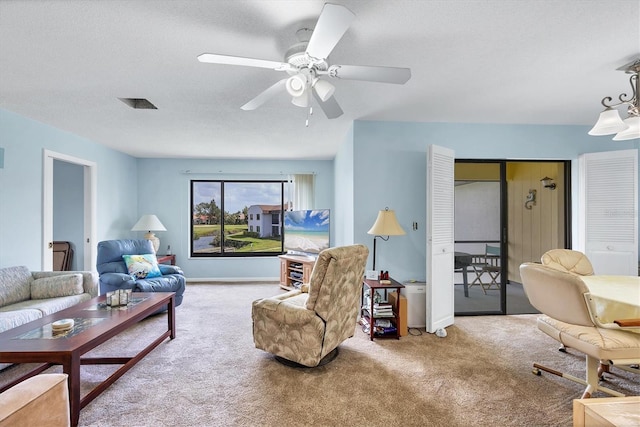 carpeted living area featuring a ceiling fan and a textured ceiling