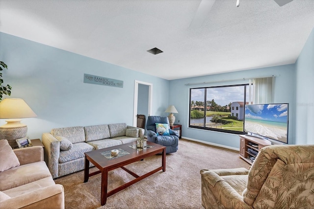 living room featuring carpet floors, a textured ceiling, and baseboards