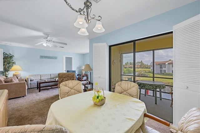 dining room with carpet floors and ceiling fan with notable chandelier