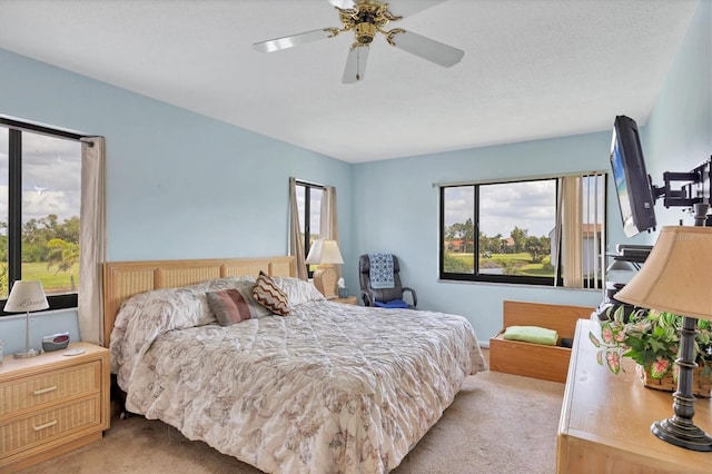 bedroom with a ceiling fan and light colored carpet