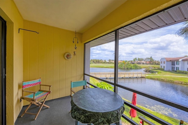 sunroom / solarium featuring a water view