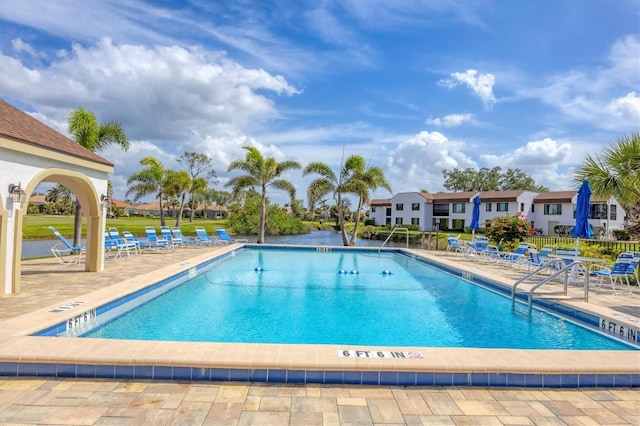 community pool with fence and a patio