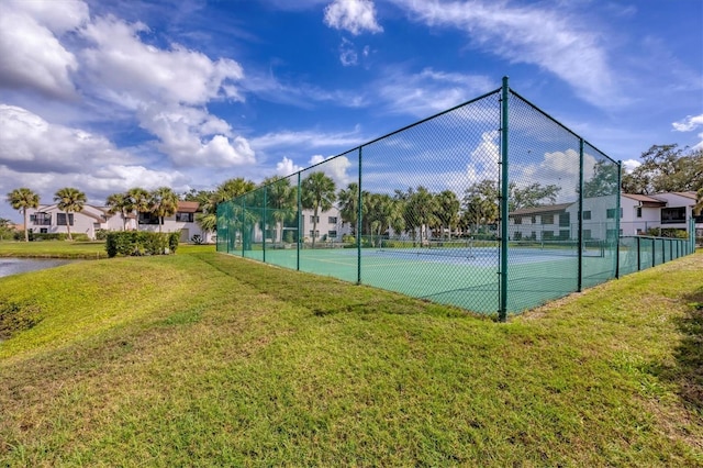 view of sport court with a yard and fence