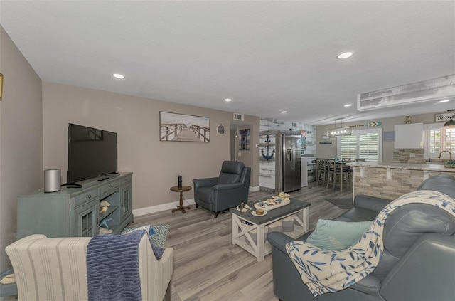 living area featuring recessed lighting, visible vents, light wood-style flooring, and baseboards