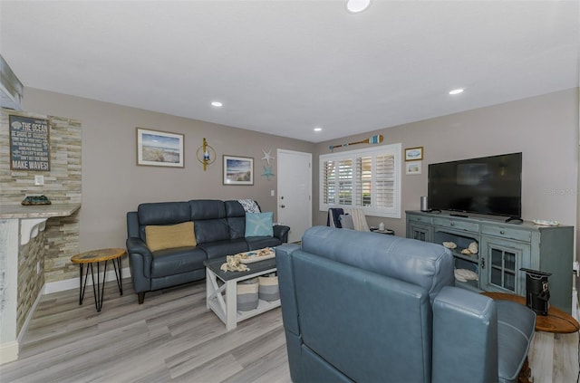 living area with baseboards, light wood-type flooring, a fireplace, and recessed lighting