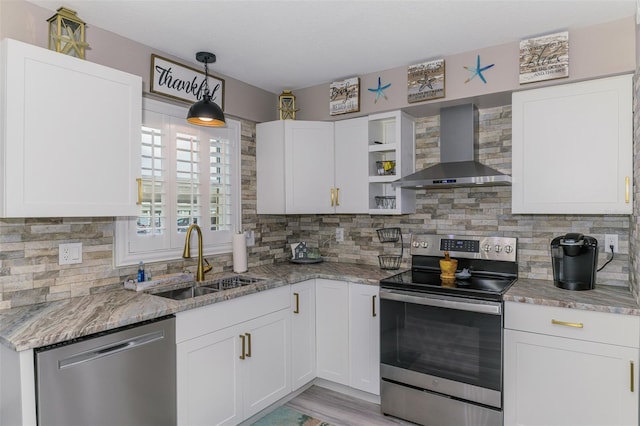 kitchen featuring stainless steel appliances, a sink, wall chimney range hood, backsplash, and open shelves