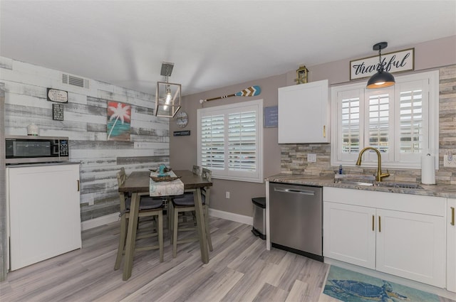 kitchen with stone counters, a sink, visible vents, white cabinetry, and appliances with stainless steel finishes