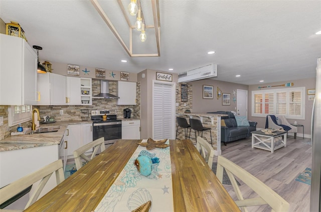 dining area with a wealth of natural light, light wood-style flooring, and recessed lighting