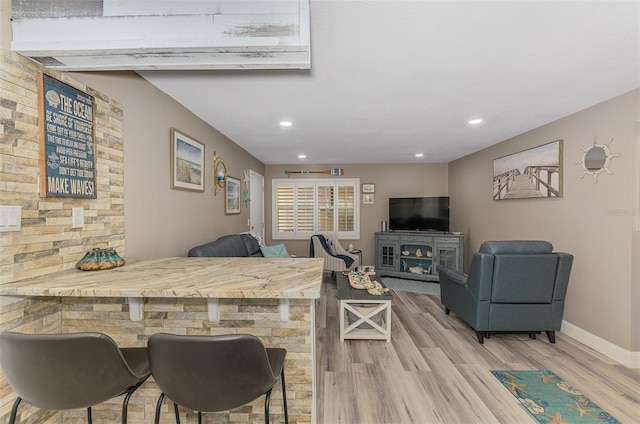 living room featuring baseboards, wood finished floors, and recessed lighting